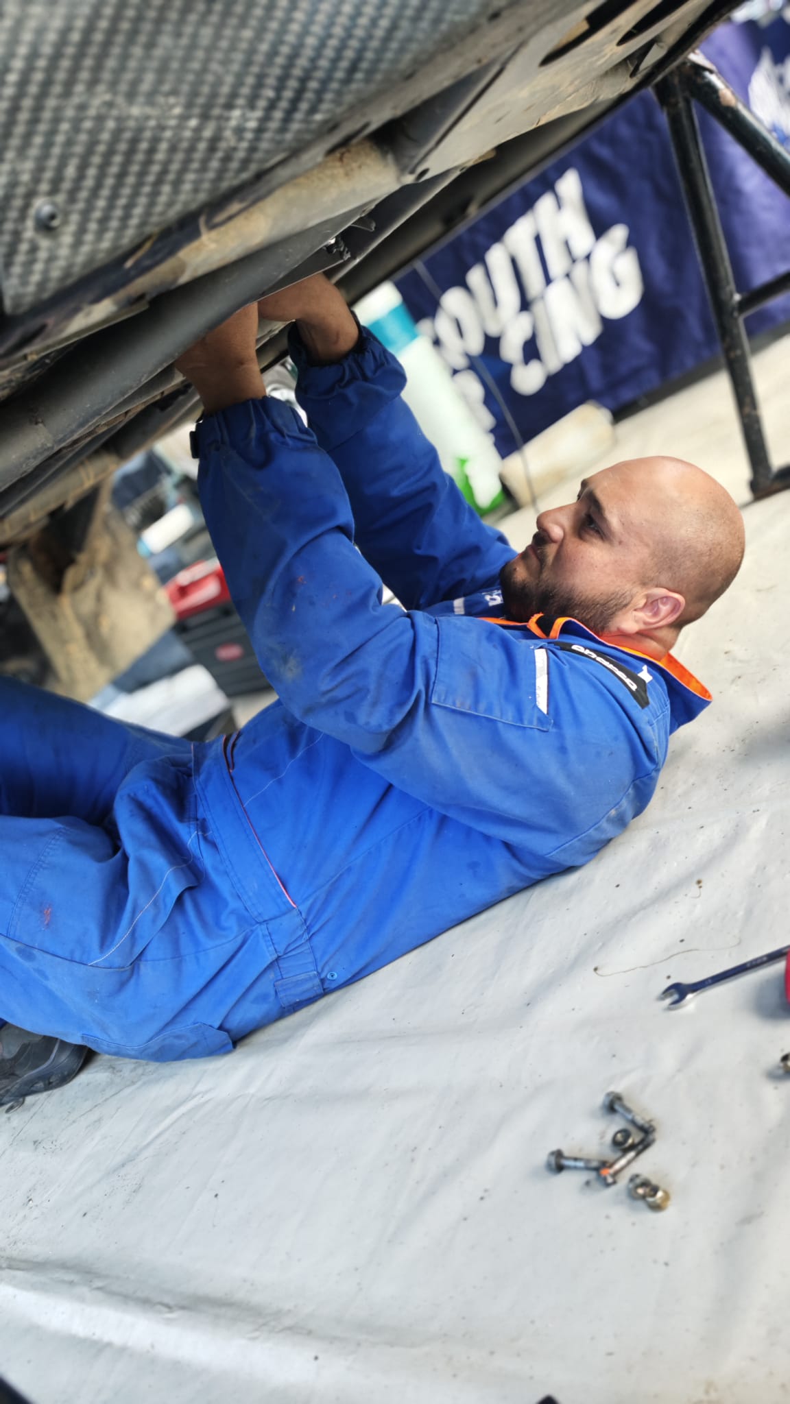 Warren Naude working beneath a rally-raid vehicle