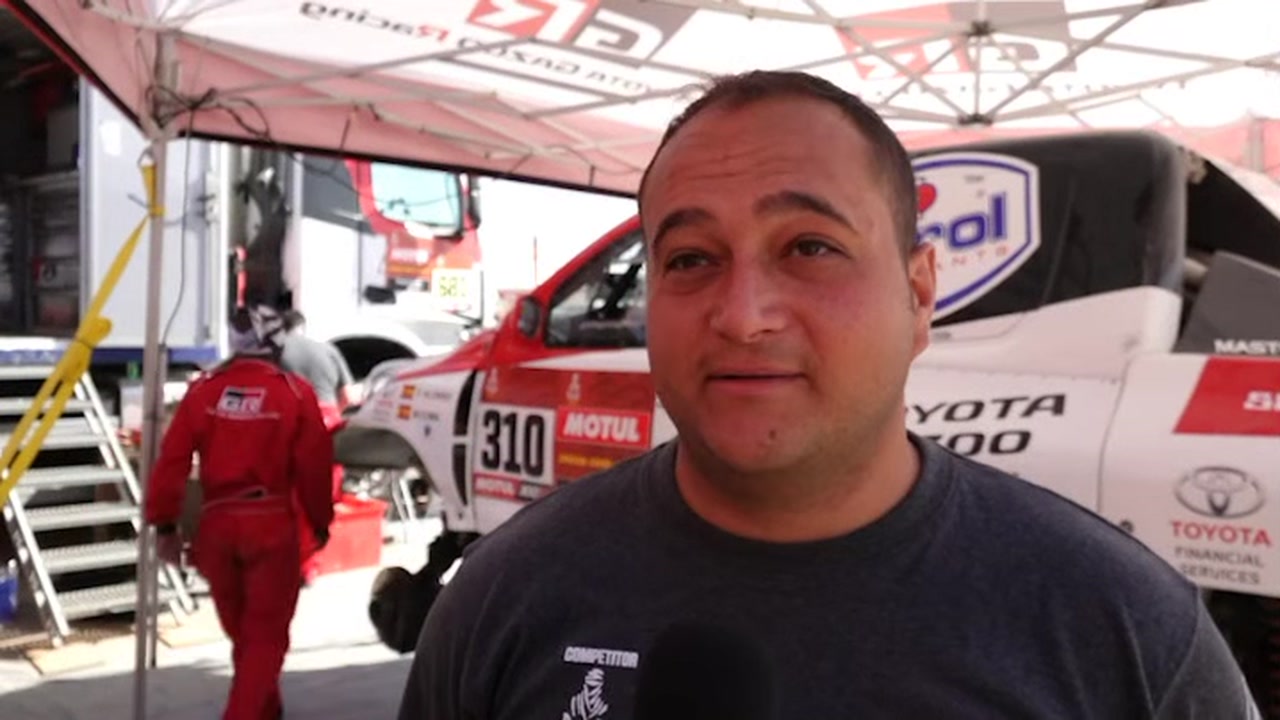 Warren Naudé speaking beside Fernando Alonso’s Toyota Hilux #310 in the video